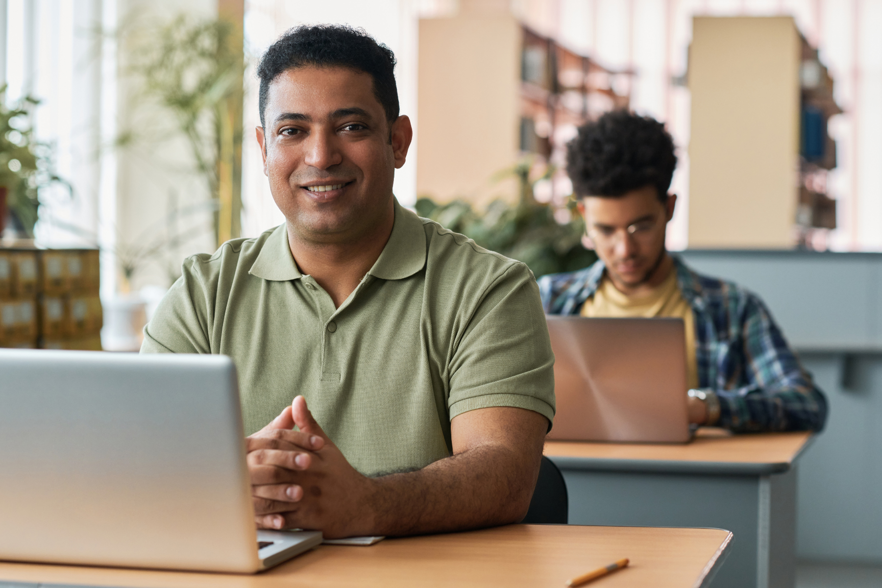 English learner smiling while studying at a laptop